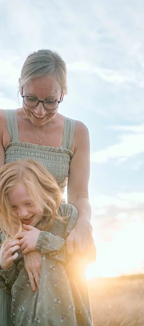 Woman and child sharing a golden-hour moment in a field