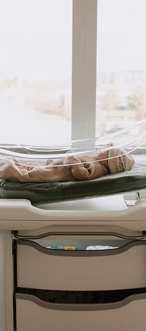 Fresh 48 photography in North DFW Newborn sleeping in a hospital bassinet beside a bright window