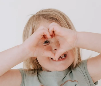 Child forming a heart with her hands