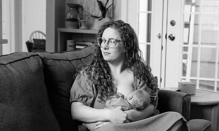 In-home motherhood photography in North DFW by Katie Burke Photography Mother breastfeeding her infant on the sofa at home
