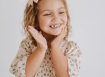 Girl laughing with her hands cupped against her cheeks
