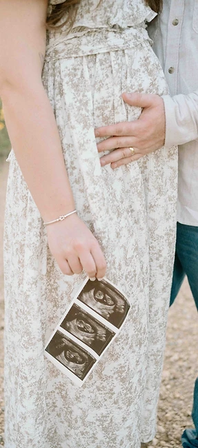 Maternity photography near Flower Mound, Texas Couple holding a sonogram print at golden hour