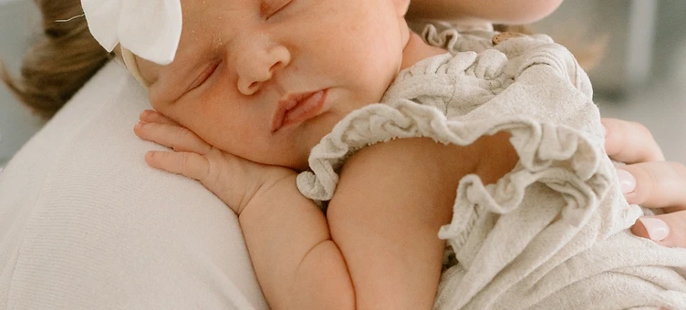 Mother holding her sleeping newborn against her shoulder