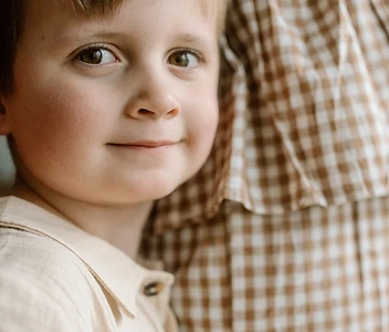 Boy resting against his mother's shoulder