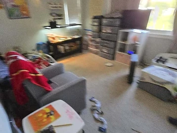 Bedroom used for temporary storage during water damage restoration with armchair and aquarium