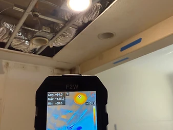 Thermal imaging camera showing heat map of kitchen ceiling with hot spot at 135.2 degrees F near a recessed light fixture