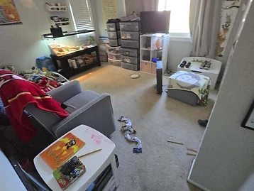 Bedroom used as temporary storage during restoration with armchair, aquarium, and storage units
