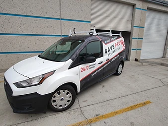 Save Pro Restoration branded service van parked in front of an industrial facility