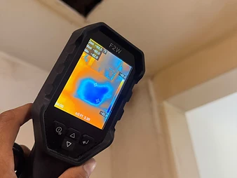 Thermal imaging camera showing temperature gradient on a ceiling surface during leak detection