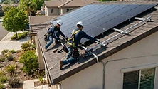 Professional solar panel installation on a modern California residential roof with clear sky background.