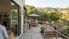 A modern outdoor living space in California featuring a custom deck and patio with comfortable seating and landscape…