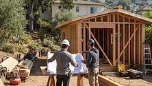 A modern backyard accessory dwelling unit with large glass doors and contemporary wood siding in a sunny California setting.