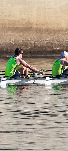 Hands gripping an oar mid-stroke