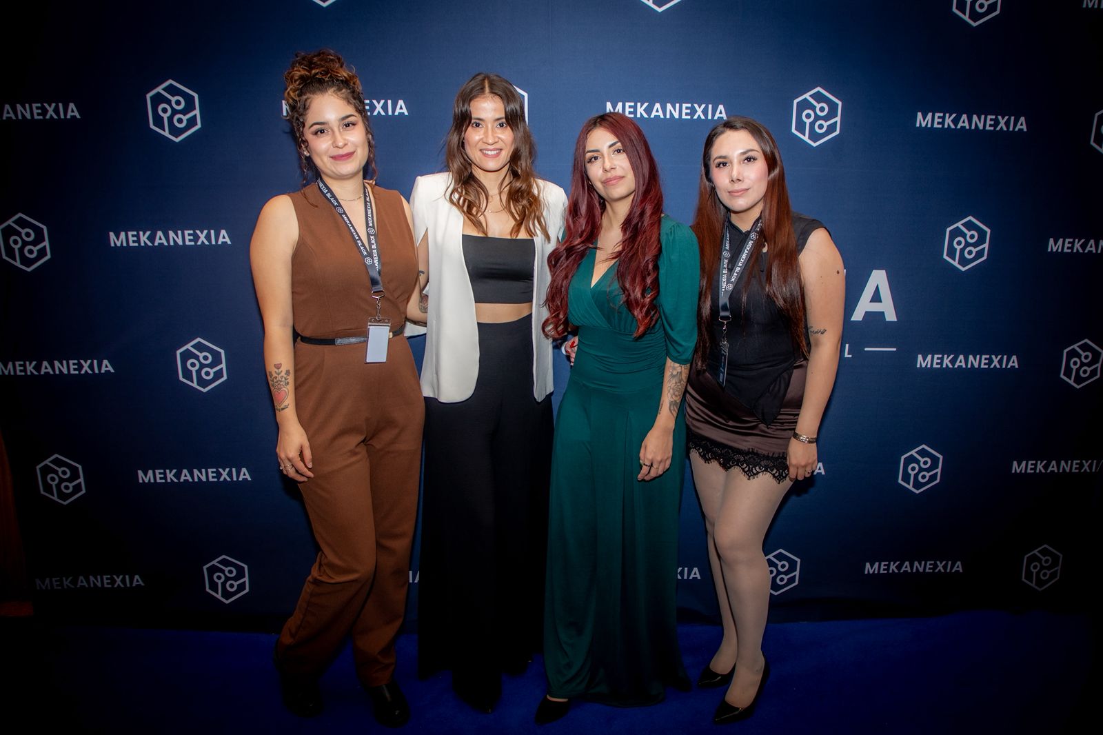 Cuatro empresarias reunidas frente al muro de Mekanexia en Meet & Wine