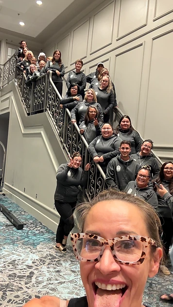 Zandra Ross celebrating with a workshop group on the venue staircase