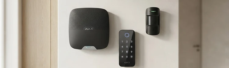 Ajax wireless security hub, keypad and motion detector installed on a hallway wall