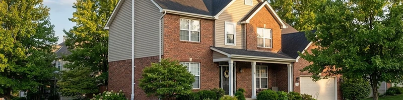 Exterior view of a Columbia, Missouri suburban home with a discreet white radon mitigation pipe
