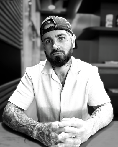 Portrait of tattoo artist Nate D in dark studio lighting