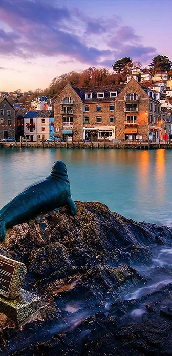 Looe harbour at dusk with Nelson the seal statue, Cornwall