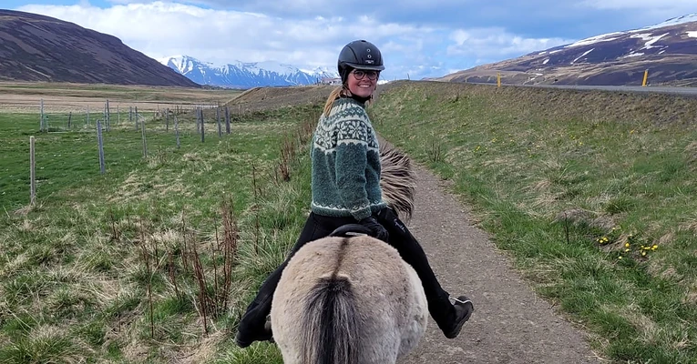 Riding along a valley trail with mountains behind