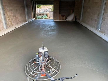 Power trowel finishing a poured concrete floor inside blockwork