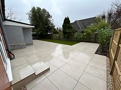 Large-format beige porcelain patio laid in a grid with dark grout lines