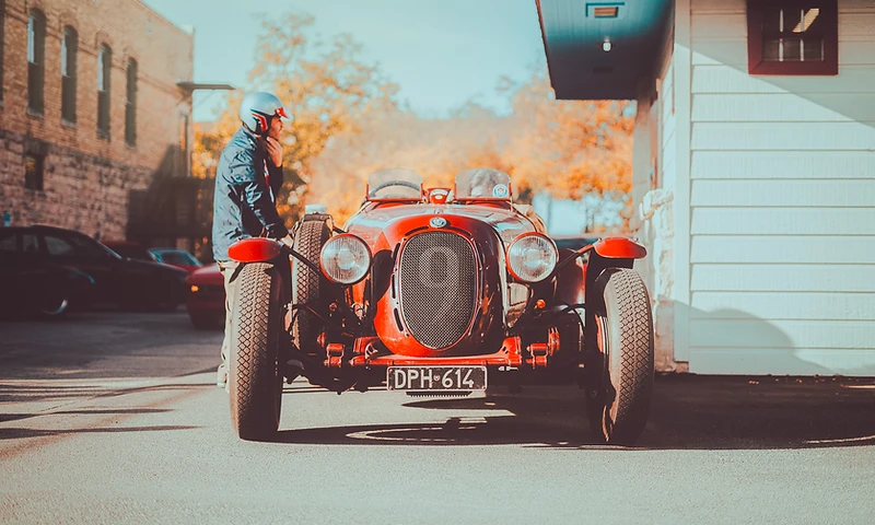 Vintage red roadster at a rally gathering