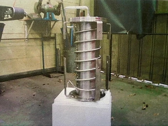 Stainless reactor vessel core with coiled tubing standing in a workshop