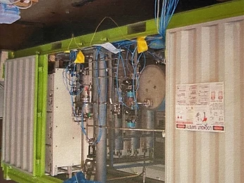 Lime-green containerised system with pipework, valves and pressurised tank