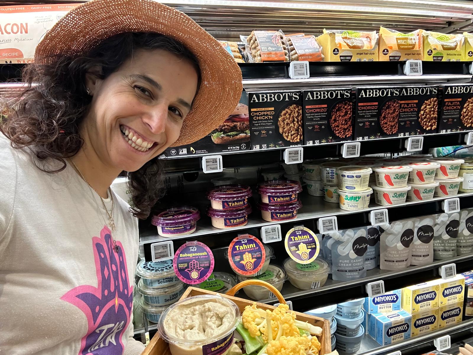 Tal in a grocery store aisle with Tal's Mediterranean products