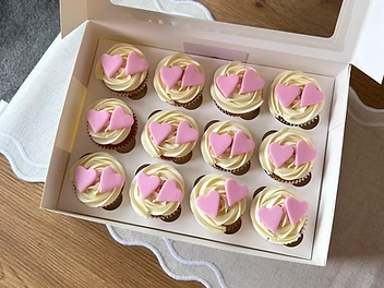 Pink frosted cupcakes with delicate gold sprinkles on a wooden cooling rack — photo 1 of 10