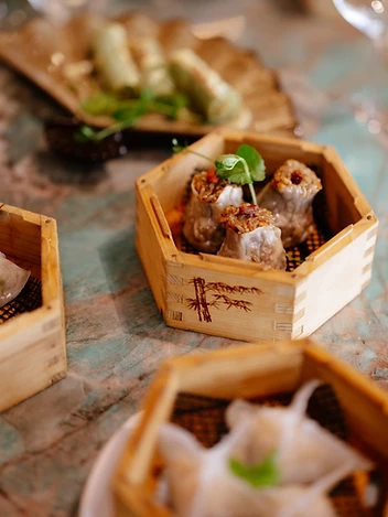 Meerdere stoommandjes met dim sum op marmeren tafel