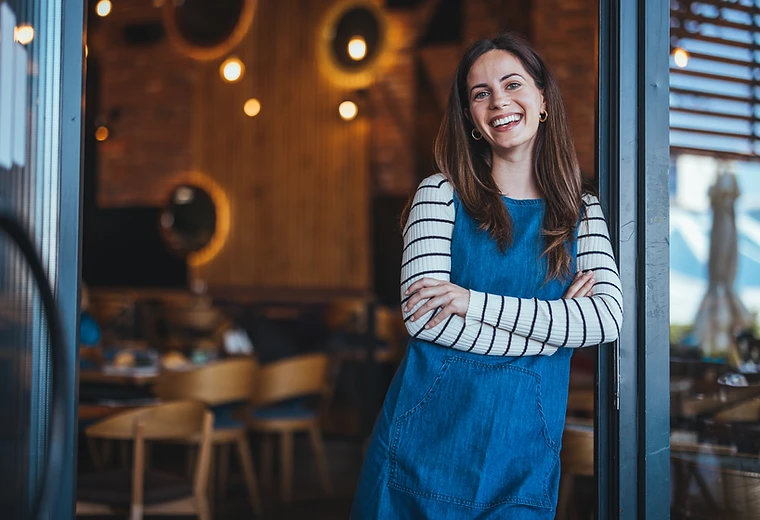 Small business owner smiling, confident with monthly bookkeeping handled by Mispar
