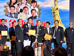 Stage presentation of certificates at A Night of Heartfelt Love, with honourees and a golden deity backdrop