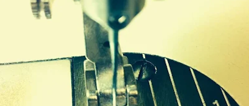 Macro close-up of a sewing machine presser foot and seam-allowance markings