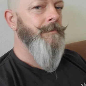 Close-up portrait of a mohawk and handlebar mustache cut