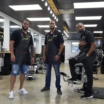 Three Seven18 barbers posing together in the lounge aisle