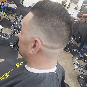 Client with a skin fade and line design in a Seven18 cape
