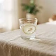 A glass of water with lemon on ivory linen