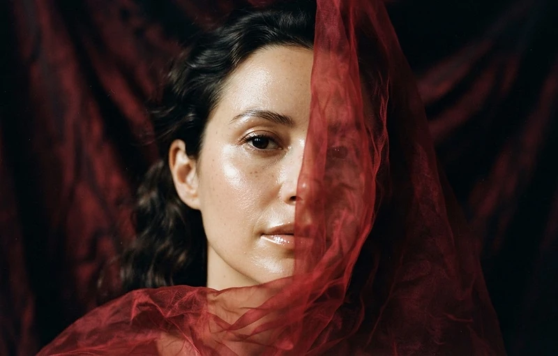 Dewy beauty portrait framed by vivid crimson silk