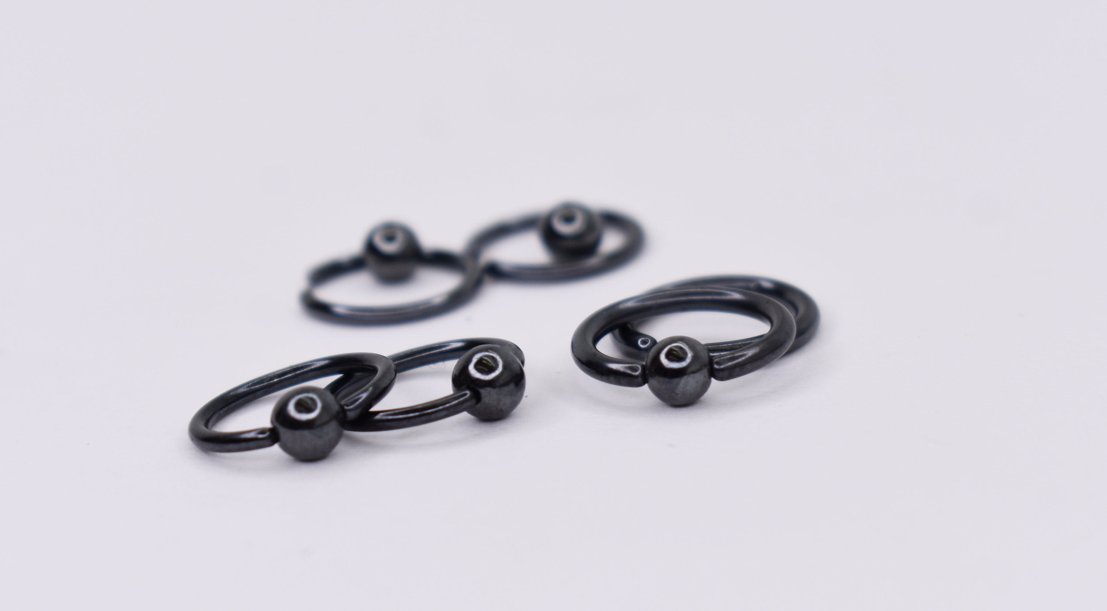 Gunmetal niobium captive bead rings with polished black finish, implant grade body jewelry manufactured in Calgary by Tribal Expression