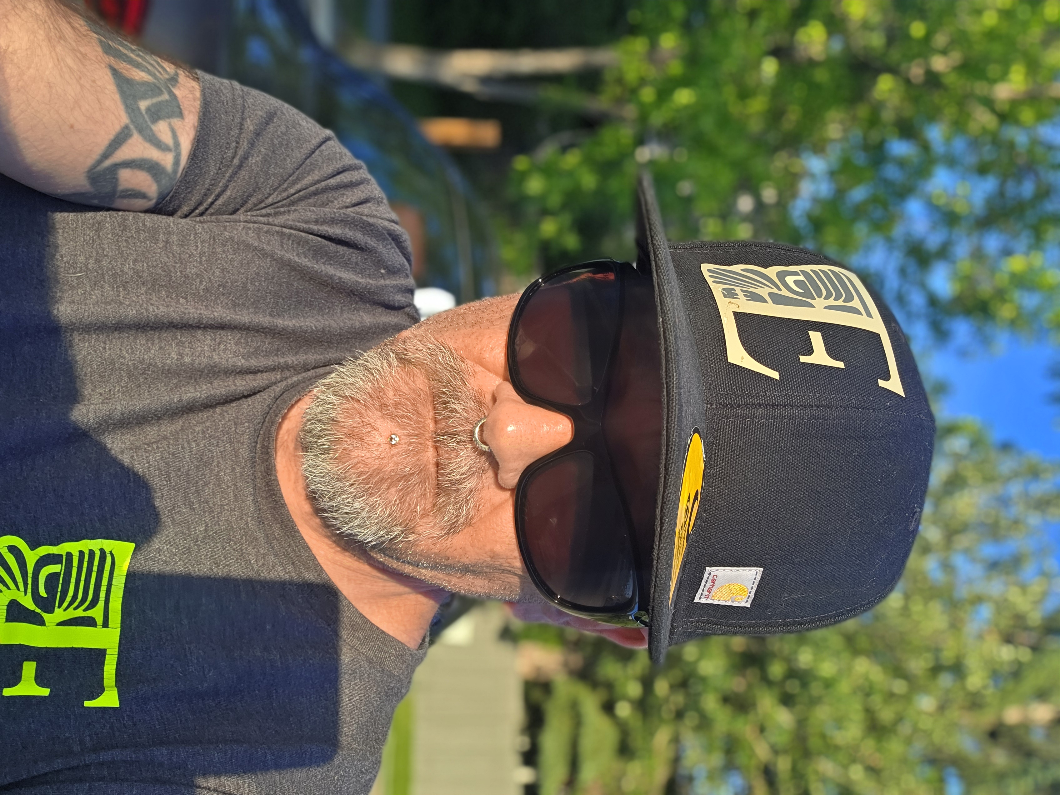 Keith Kennedy, founder and owner of Tribal Expression, wearing a black cap and sunglasses outdoors