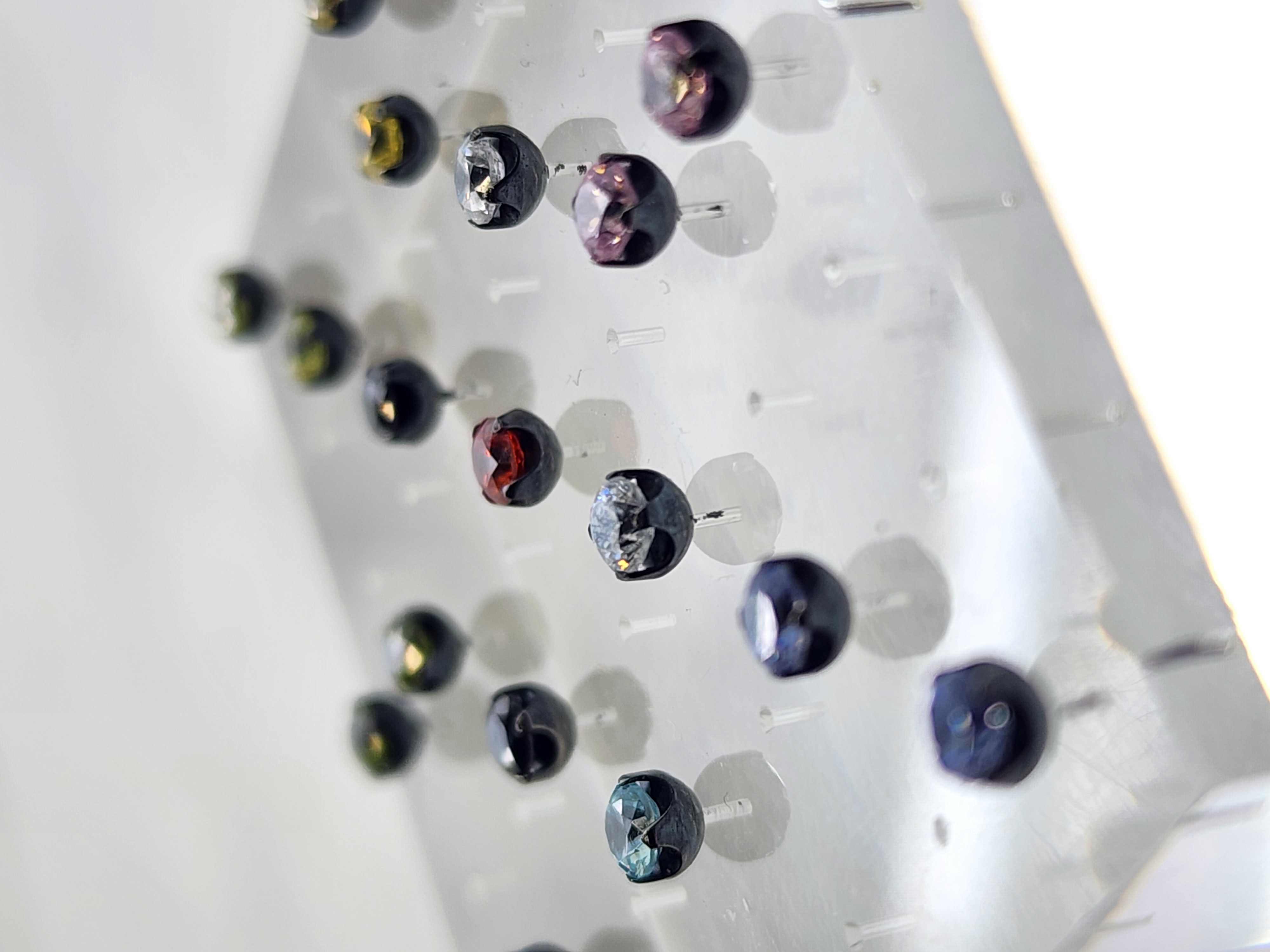 Gem set body jewelry studs on a translucent display stand at Tribal Expression in Calgary Alberta