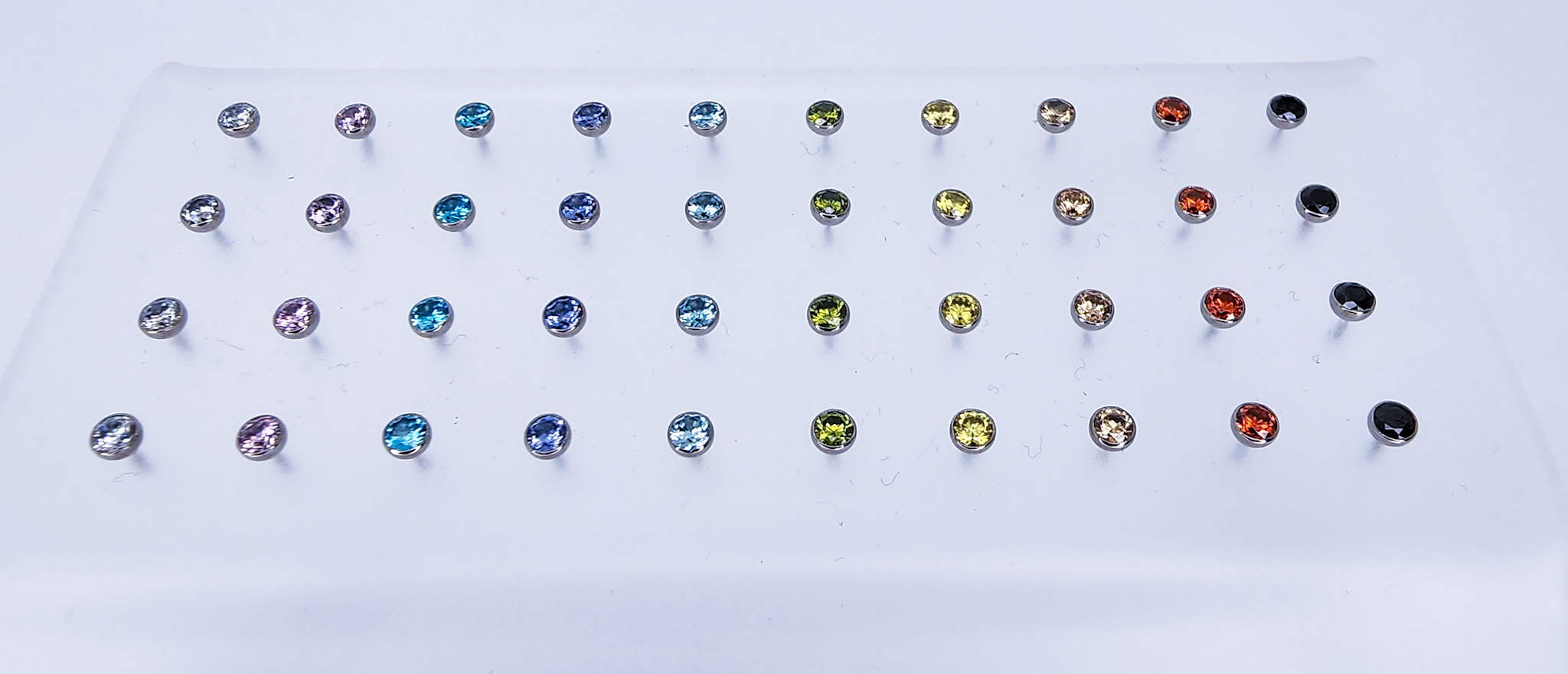 Gemstone stud earrings in many colours on a display stand, Calgary made body jewelry from Tribal Expression