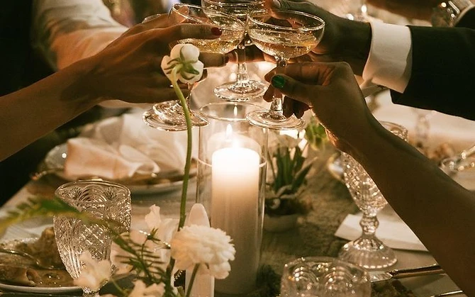 Glasses raised in a candlelit toast