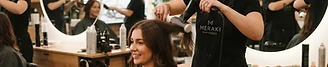 A stylist styling a client's hair in a salon