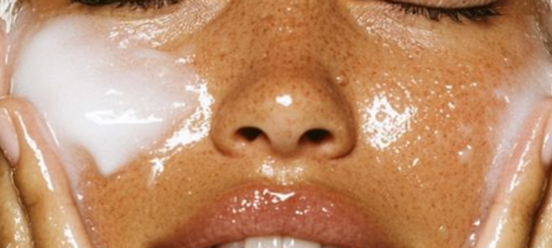 Close-up of hands cupping a face with a luminous skincare ritual