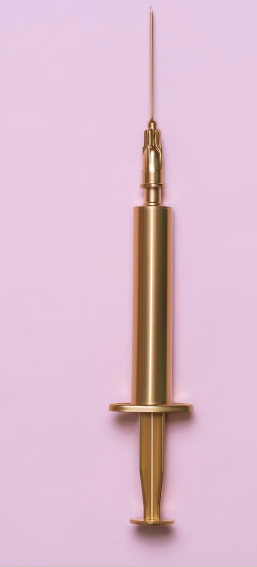 A single metallic gold syringe centered on a pale pink background