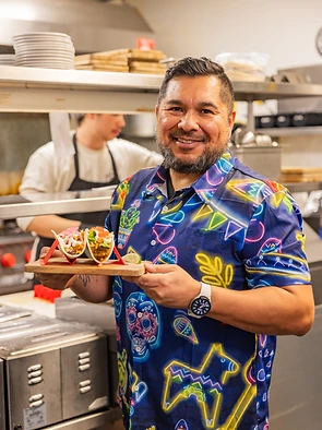 Fiesta Tacos & Tequila kitchen team member serving tacos