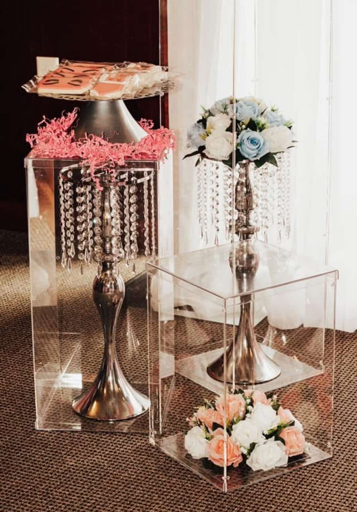 Acrylic display pedestals with crystal stands and floral arrangements